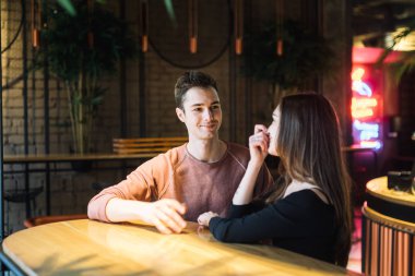 Tema aşk ve tatil Sevgililer günü. Üniversite öğrencileri birlikte beyaz heteroseksüel severler kış kafe içinde birkaç boş tablo kucaklama otur. Duygu mutluluk ve sevgi.