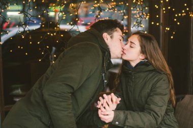 Tema aşk Tatil Sevgililer günü. Çift üniversite öğrencileri, kış, beyaz heteroseksüel severler arka plan pencere ışıklar karşı cadde kafe masaya oturabiliriz. Mutluluk ve sevgi duygu romantizm.