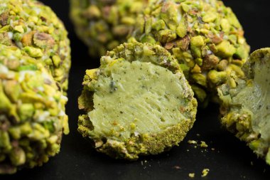 Tema şekerli tatlı pasta el yapımı. Makro yakın çekim tatlı tatlı tatlı şeker yuvarlak top beyaz trüf topu küme beyaz çikolata, matcha çay ve siyah bir zemin üzerine Antep fıstığı.