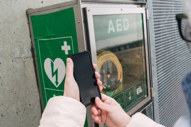 Tıp Kardiyopulmoner resüsitasyon acil çağrı yapıyorum. Kafkas kadın 911 yardım aramakta telefon kullanır. Cihaz kutusu aed otomatik defibrilatör hastalıkları, klinik ölüm, kalp durması ve kalp krizi