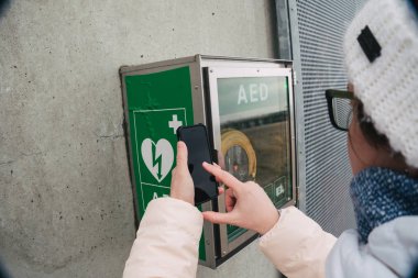 Tıp Kardiyopulmoner resüsitasyon acil çağrı yapıyorum. Kafkas kadın 911 yardım aramakta telefon kullanır. Cihaz kutusu aed otomatik defibrilatör hastalıkları, klinik ölüm, kalp durması ve kalp krizi