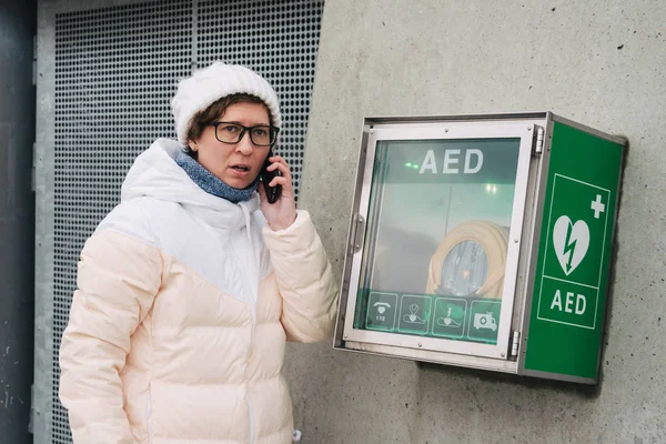 medicine cardiopulmonary resuscitation emergency call. Caucasian woman uses telephone calling 911 help. device box aed automatic defibrillator diseases, clinical death, cardiac arrest and heart attack