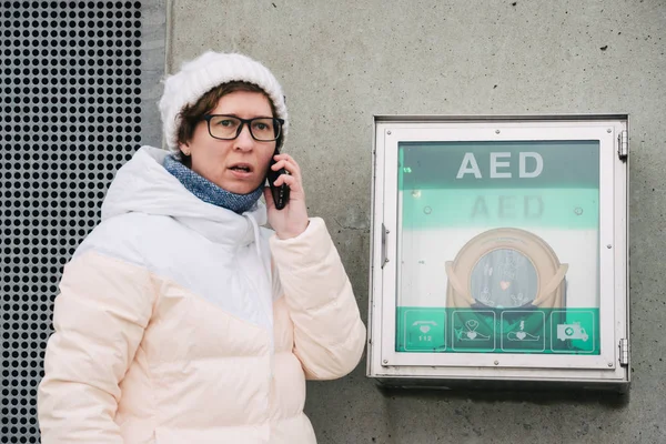 medicine cardiopulmonary resuscitation emergency call. Caucasian woman uses telephone calling 911 help. device box aed automatic defibrillator diseases, clinical death, cardiac arrest and heart attack