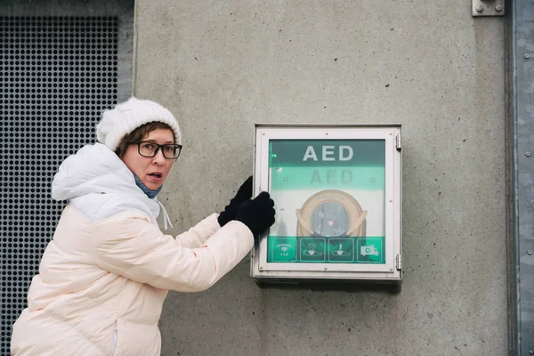 medicine cardiopulmonary resuscitation and emergency call. Young caucasian woman asking for help. device box aed automatic defibrillator for diseases, clinical death, cardiac arrest and heart attack.