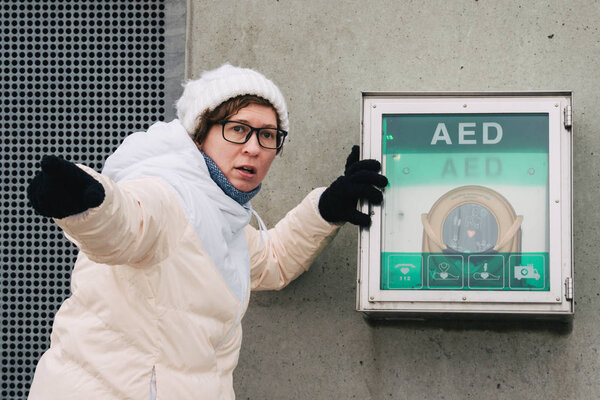 medicine cardiopulmonary resuscitation and emergency call. Young caucasian woman asking for help. device box aed automatic defibrillator for diseases, clinical death, cardiac arrest and heart attack.