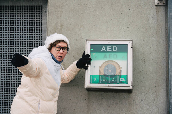 medicine cardiopulmonary resuscitation and emergency call. Young caucasian woman asking for help. device box aed automatic defibrillator for diseases, clinical death, cardiac arrest and heart attack.