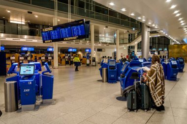 18 Şubat 2019. Kastrup Havaalanı Danimarka Kopenhag. Bağımsız olarak kontrol monitör ekran Havaalanı terminal kullanarak elektronik bilet uçuşta büyük bavul Bagaj ile kadın tanınmaz yedekler