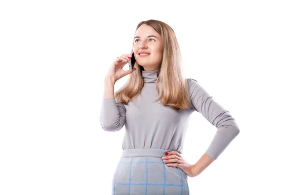 The theme of a business woman and telephone conversations. Beautiful young caucasian woman uses a smartphone handset to call in formal clothes on a white isolate background — Stock Photo, Image