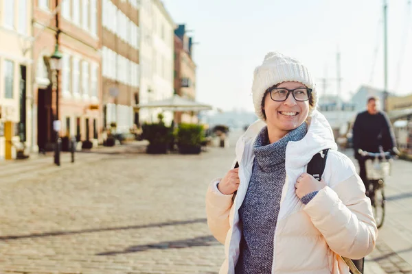 Портрет молодих кавказьких європейських жінка у якості туриста окуляри для подання білому капелюсі і пуховик з чорний рюкзак, постановка на вуличку Європи в міста Копенгаген у Данії — стокове фото