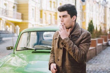 Esmer Türk Orta Doğu esmer bir sigara sokaktaki eski retro car yakınındaki poz ile bir modeli genç yakışıklı seksi erkek esmer bir adam portresi