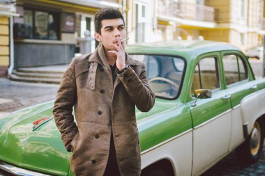 Esmer Türk Orta Doğu esmer bir sigara sokaktaki eski retro car yakınındaki poz ile bir modeli genç yakışıklı seksi erkek esmer bir adam portresi