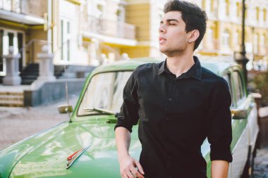 Esmer Türk Orta Doğu esmer bir sigara sokaktaki eski retro car yakınındaki poz ile bir modeli genç yakışıklı seksi erkek esmer bir adam portresi