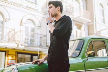 Esmer Türk Orta Doğu esmer bir sigara sokaktaki eski retro car yakınındaki poz ile bir modeli genç yakışıklı seksi erkek esmer bir adam portresi