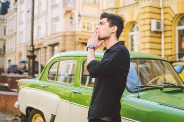 Esmer Türk Orta Doğu esmer bir sigara sokaktaki eski retro car yakınındaki poz ile bir modeli genç yakışıklı seksi erkek esmer bir adam portresi