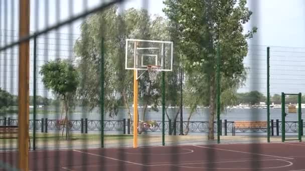 Boş açık basketbol sahası iki Basketbol çember ve yeşil ağaçlar arka plan ile. 4 k çözünürlükte vurdu — Stok video