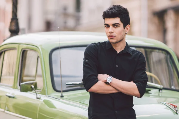 Retrato, guapo, hombre, modelo, morena raza mediterránea hombre turco se encuentra cerca de un coche retro de color verde posando en una camisa negra y jeans en la ciudad —  Fotos de Stock