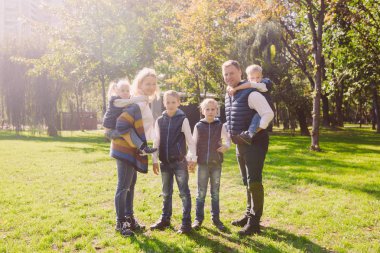 Tema aile etkin boş dışında doğada. büyük beyaz dört çocuklu bir aile. Annem ve babam aktif rahatlatıcı. çimenlerin üzerinde evi Parkı hayattan zevk. Arka omuz çocuklara top rulo