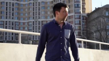 Konu işadamı kızgın telefonla konuşuyor. Genç Beyaz esmer erkek gömlek. Küçük işletme işçisi. Bir meslek. Satış Müdürü. Emlakçı smartphone kullanır. Duygu öfke ve nefret karşı bina