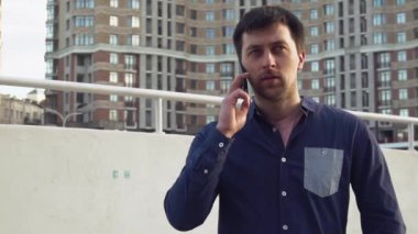 Konu işadamı kızgın telefonla konuşuyor. Genç Beyaz esmer erkek gömlek. Küçük işletme işçisi. Bir meslek. Satış Müdürü. Emlakçı smartphone kullanır. Duygu öfke ve nefret karşı bina
