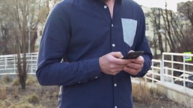 İnsan hakları ve sosyal SETI Tema. Molodoy beyaz adam elinde cep telefonu kullanarak, Sms Internet'i kullanan yazma, sohbet oturan sokakta yürüyen esmer rushke