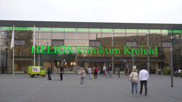 19 de octubre de 2018. Alemania, Krefeld. Entrada exterior edificio del hospital. Puertas correderas fachada de vidrio clínica europea. Territorio y área de recreación. Personas caminan visitantes — Vídeo de stock