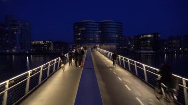 18 Şubat 2019. Danimarka, Copenhagen. Yaya Köprüsü iki bölüme ayrılmıştır: bir bisiklet yolu ve bir yürüyüş yolu. Şehir gece görünümü asma ile. Taşıma Bisiklet Avrupa'nın ekolojik görünümü