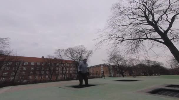 Der erwachsene Mensch freut sich wie ein Kind. Spielplatz-Trampolin im Boden, Kinder-Trampolin, Federn wirft die Menschen Spaß und cool. Kopenhagen. Frau springt auf Trampolin — Stockvideo