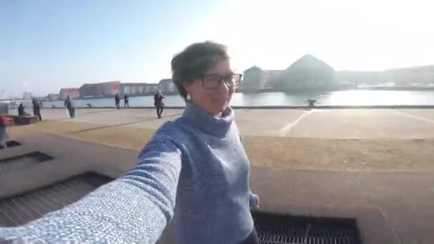 Pessoa adulta se alegra como criança. O trampolim do campo de jogos no chão, trampolim das crianças, molas joga povos acima do divertimento e fresco. Copenhaga Rio Embankment Dinamarca. Mulher pulando no trampolim de rua — Vídeo de Stock