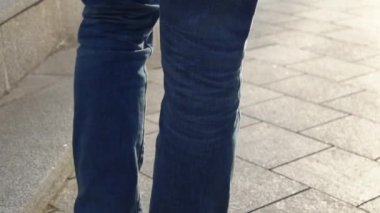 Kırmızı Ayakkabı ve kot güneşli havalarda bir şehir sokak merdivenlerde yürüyen genç bir erkekte bacaklar Close-Up
