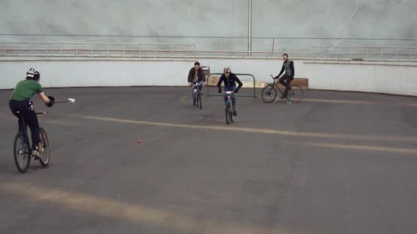 2019 年 3 月 17 日。ウクライナ、キエフ。ポロのバイクゲーム。シティー バイクの人チームのグループのトレーニングには、スタジアムのチーム ゲームをプレイします。彼の手で棒で自転車の男性は、ゴールにボールをキックします。 — ストック動画