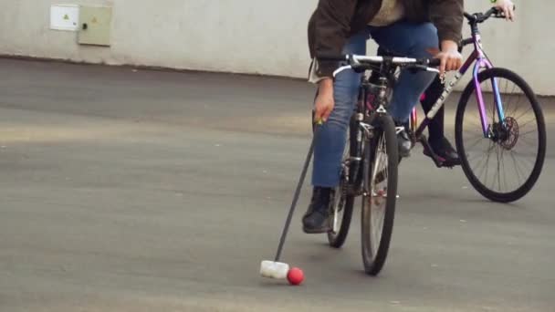 March 17, 2019. Ukraine, Kiev. Bike polo game. group of people team on city bikes are training playing team game in stadium. man on bicycle with stick in his hands kicks ball into the goal — Stock Video