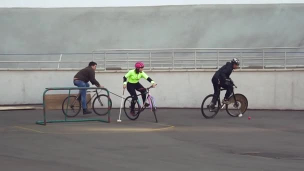 17 de marzo de 2019. Ucrania, Kiev. Juego de polo en bicicleta. grupo de personas equipo en bicicletas de la ciudad están entrenando jugando juego de equipo en el estadio. hombre en bicicleta con palo en las manos patea la pelota en la portería — Vídeos de Stock