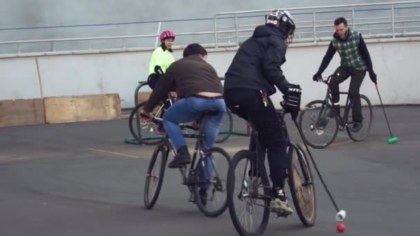 17 marca 2019. Ukraina, Kijów. Gry Bike polo. Grupa osób zespołu na rowery górskie są szkolenia, gra zespół gra na stadionie. człowiek na rowerze z kijem w ręku wykopuje piłkę do bramki — Wideo stockowe