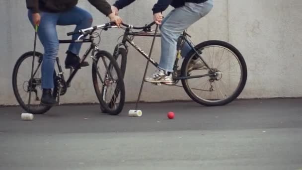 17 de marzo de 2019. Ucrania, Kiev. Juego de polo en bicicleta. grupo de personas equipo en bicicletas de la ciudad están entrenando jugando juego de equipo en el estadio. hombre en bicicleta con palo en las manos patea la pelota en la portería — Vídeo de stock