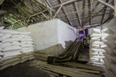 Tema bitki depo. Bir sürü beyaz kumaş çanta gevşek ürünleri ile üretimde kapalı kazık büyüğe. Bitmiş ürün paket içinde saklamak için Angar. Nakliye teyp