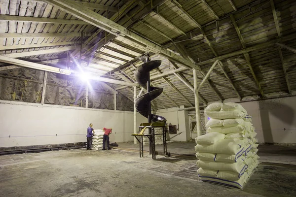 El tema de la producción y el procesamiento. Mecanismos en la antigua planta de baja tecnología para la producción de grano. Tiempos de fábrica de la Unión Soviética. Transporte de mercancías en la empresa . —  Fotos de Stock