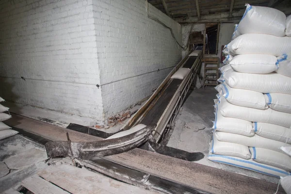 El tema de la producción y el procesamiento. Mecanismos en la antigua planta de baja tecnología para la producción de grano. Tiempos de fábrica de la Unión Soviética. Transporte de mercancías en la empresa . —  Fotos de Stock