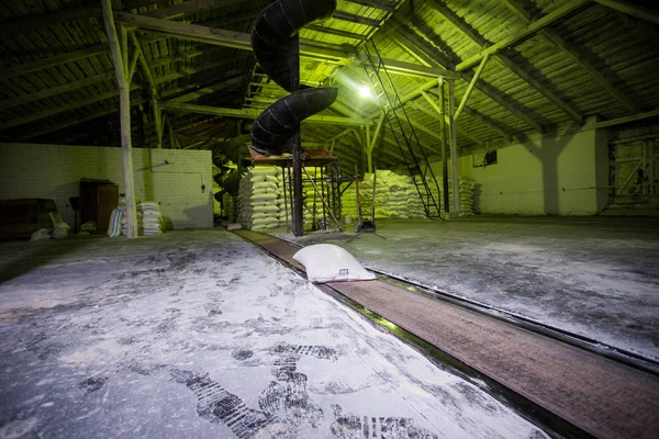 El tema de la producción y el procesamiento. Mecanismos en la antigua planta de baja tecnología para la producción de grano. Tiempos de fábrica de la Unión Soviética. Transporte de mercancías en la empresa . —  Fotos de Stock