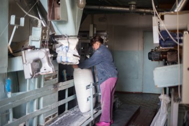 14 Ekim 2014.Ukraine.Kyiv.Work tarım ürünleri üretim. Bir iniform giymiş beyaz bir kadın iş paketleri büyük torbalar içine ürünler toplu bir konveyör gerçekleştirir.