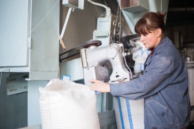 14 Ekim 2014.Ukraine.Kyiv.Work tarım ürünleri üretim. Bir iniform giymiş beyaz bir kadın iş paketleri büyük torbalar içine ürünler toplu bir konveyör gerçekleştirir.