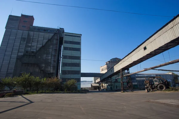 The territory of the old plant. Buildings for food storage and transportation. The metal structures of the tower and towers in the obsolete plant of Eastern Europe, the impact on environmental polluti