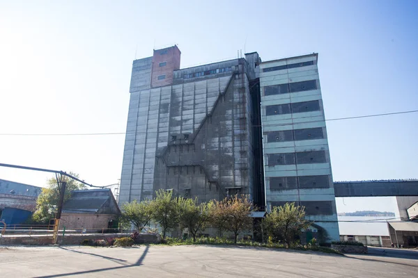 El territorio de la antigua planta. Edificios para almacenamiento y transporte de alimentos. Las estructuras metálicas de la torre y las torres en la obsoleta planta de Europa del Este, el impacto sobre los contaminantes ambientales —  Fotos de Stock