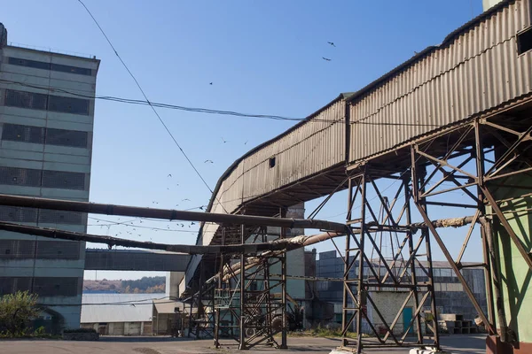 El territorio de la antigua planta. Edificios para almacenamiento y transporte de alimentos. Las estructuras metálicas de la torre y las torres en la obsoleta planta de Europa del Este, el impacto sobre los contaminantes ambientales —  Fotos de Stock