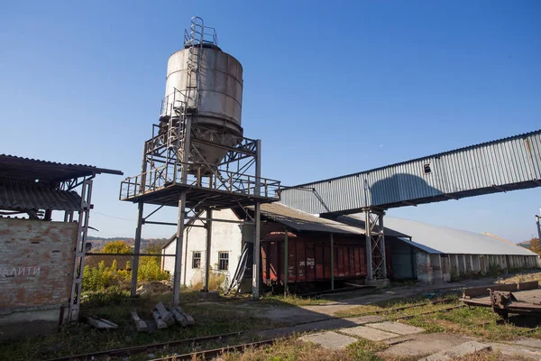 El territorio de la antigua planta. Edificios para almacenamiento y transporte de alimentos. Las estructuras metálicas de la torre y las torres en la obsoleta planta de Europa del Este, el impacto sobre los contaminantes ambientales —  Fotos de Stock