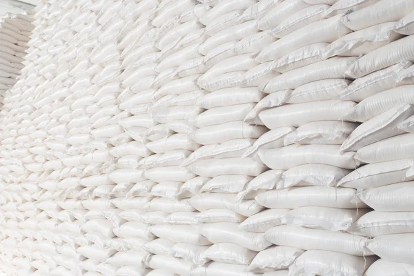 Industria temática y economía, existencias en stock.A gran cantidad de bolsas de tela blanca de cerca con productos sueltos apilados en pilas en el interior de la producción. Angar para almacenar el producto terminado en el paquete . —  Fotos de Stock