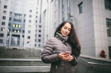 Kadın akıllı telefon dokunmatik ekrana yazarak, Businesswoman dışında modern akıllı telefon kullanarak, Hesap Yöneticisi açık çalışma, bulanık arka plan