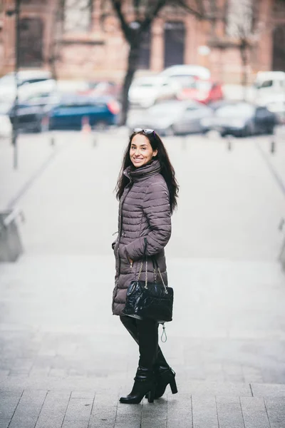 Mulher elegante atraente posando na rua na roupa da moda, segurando bolsa de camurça, vestindo jaqueta e botas altas, estilo primavera outono — Fotografia de Stock