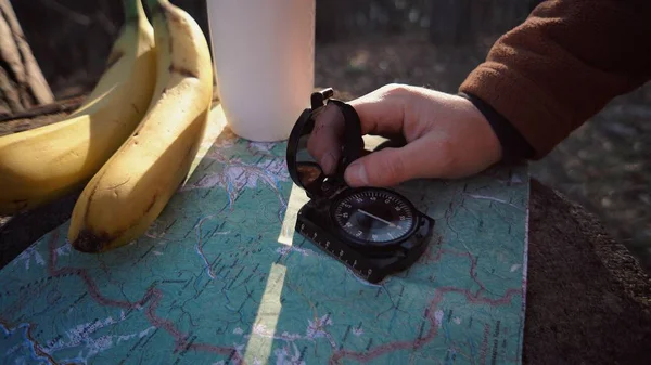 Tema vandring och natur resor. Händer kaukasiska manliga turist bryta Fällda träd, stubbe i skogen höst soligt väder. Söka riktning med kompass på kartan. Tema navigation och plotta rutt — Stockfoto