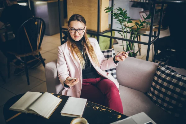 Tema modern meslek kadın Blogger. Gözlük ve ceket ile ahşap masa arkasındaki kahve dükkanında oturan beyaz kadın Notebook, dizüstü bilgisayar ve fincan kahve. Kız duygu rüya, yazar düşünüyorum — Stok fotoğraf