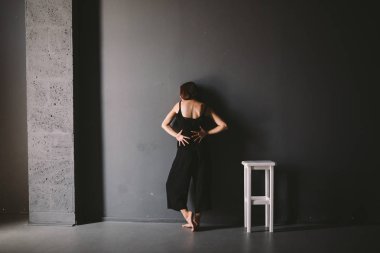 kadın yalnızlık sosyal teması ağrı acı olduğunu. Erkek aile içi şiddetin abastrasyonu. Siyah kıyafetler genç güzel kafkas kadın, garip poz, beyaz sandalye büyük karanlık oda. Korku ve umutsuzluk